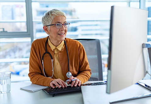 A physician working on a computer in her office